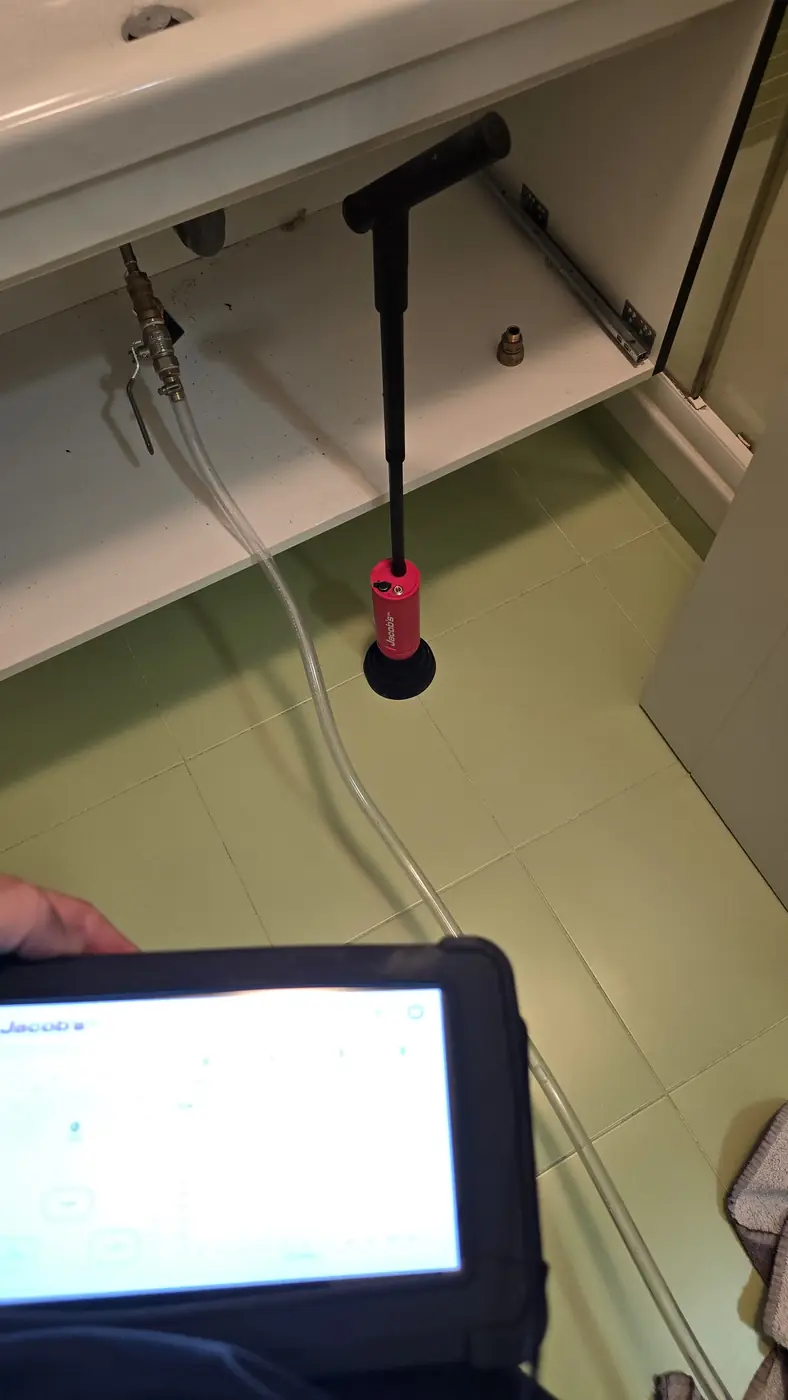 Equipo de gas traza conectado a la llave de escuadra de un baño para localizar una fuga de agua sin obra en A Coruña
