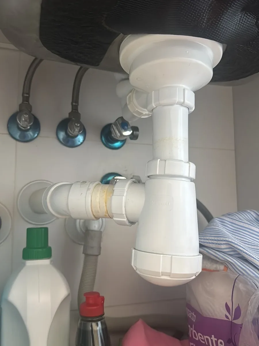 Sifón y tuberías bajo fregadero con fuga reparada por fontanero de Rifonca Servicios en A Coruña