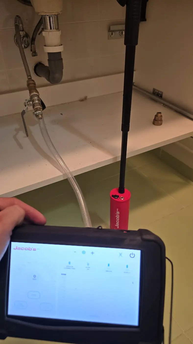 Sonda detectora de hidrógeno y tablet de lectura durante una detección de fuga con gas traza bajo el lavabo en A Coruña